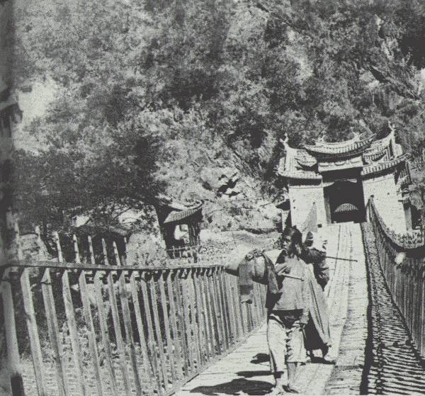 THE MEKONG BRIDGE

A drop occurs from 8,000 feet to 4,000 feet, and then a climb again over
precipitous mountains—very hard going—to 8,000 feet. Shrines are at each
end of the handsome suspension bridge.