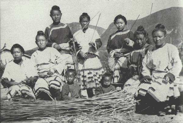 WOMEN WEAVING HEMP GARMENTS

These two pictures show (below) the women stripping hemp and (above)
weaving it into the picturesque garments they are wearing. They were all
dressed up for the occasion. It is surprising what they can do with such
primitive appliances. Picture was taken in the hill country beyond
Chaotungfu. They are all Hua Miao.