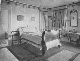 The wallpaper border, the bedspread, the table cover, and
the curtains are all wrong in this room. The Empire bed is good but
should not have castors.