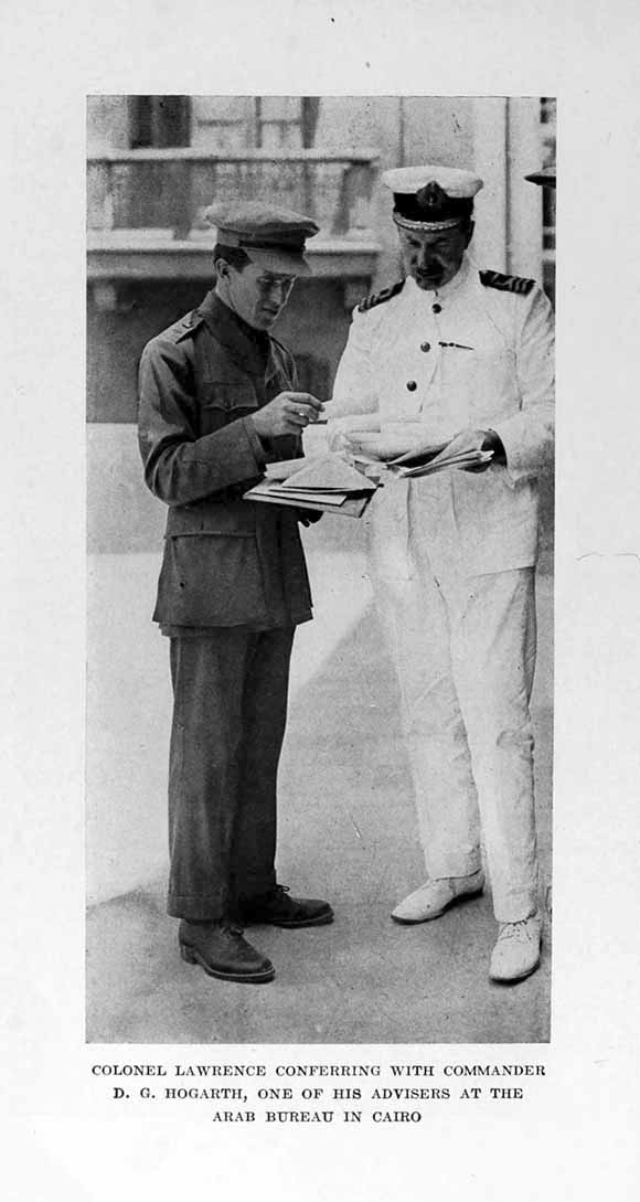 Photograph: COLONEL LAWRENCE CONFERRING WITH COMMANDER
D. G. HOGARTH, ONE OF HIS ADVISERS AT THE ARAB BUREAU IN CAIRO